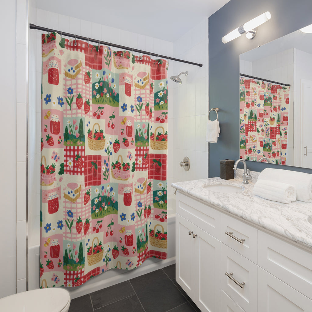 A colorful shower curtain with a strawberry and basket pattern hanging in a white tiled bathroom next to a marble countertop and sink.