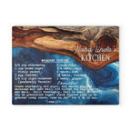 A rectangular decorative sign or print featuring a rustic wood-and-water background with the text 'Nana Linda's KITCHEN' and a cookie recipe printed below in white script and block lettering.