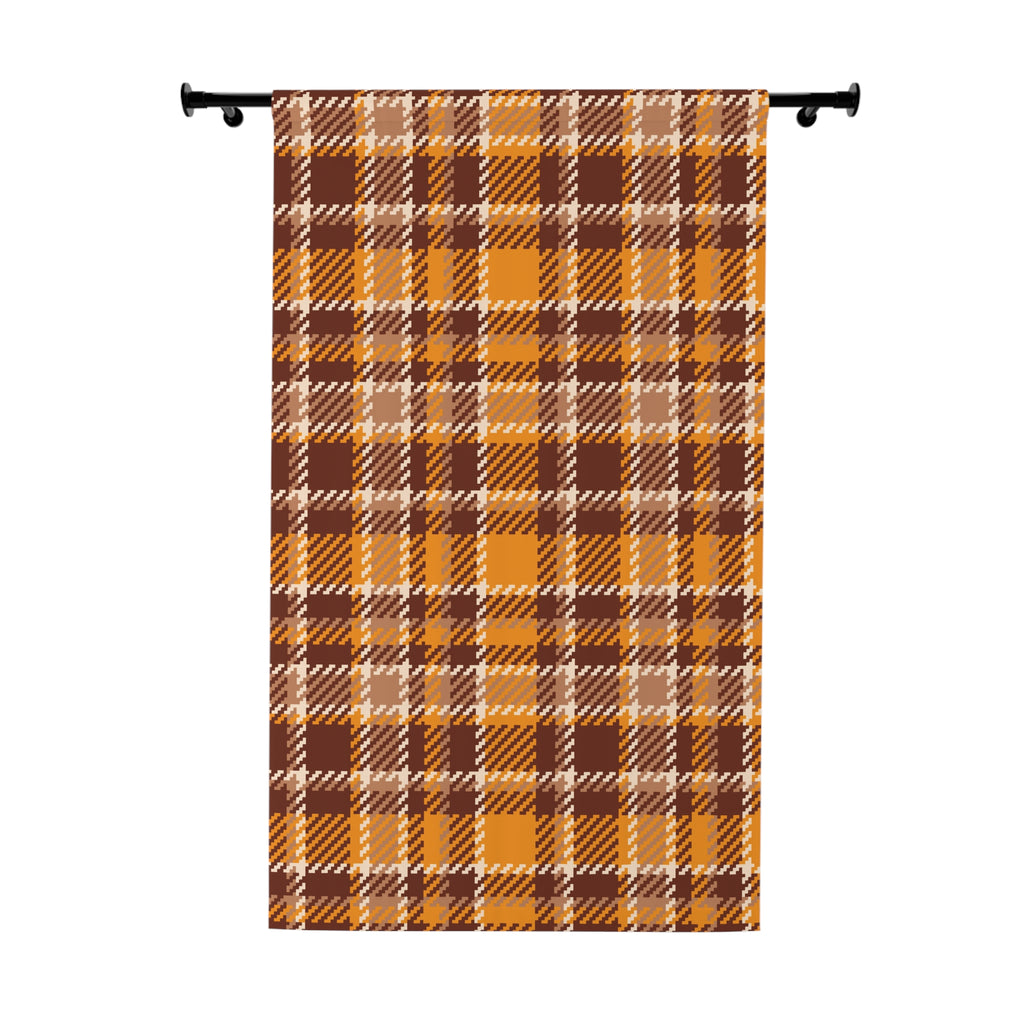 A vertical fabric panel or curtain featuring a classic autumn plaid pattern in orange, brown, beige, and white, hanging from a black rod against a plain white background.