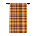 A vertical fabric panel or curtain featuring a classic autumn plaid pattern in orange, brown, beige, and white, hanging from a black rod against a plain white background.
