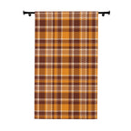 A vertical fabric panel or curtain featuring a classic autumn plaid pattern in orange, brown, beige, and white, hanging from a black rod against a plain white background.