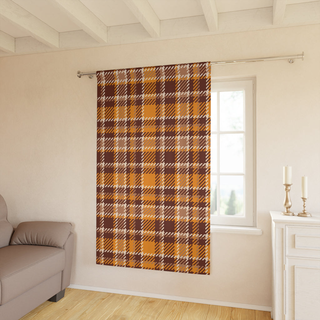 A single window curtain panel with a brown, orange, and beige plaid pattern hanging on a silver rod in a bright living room.