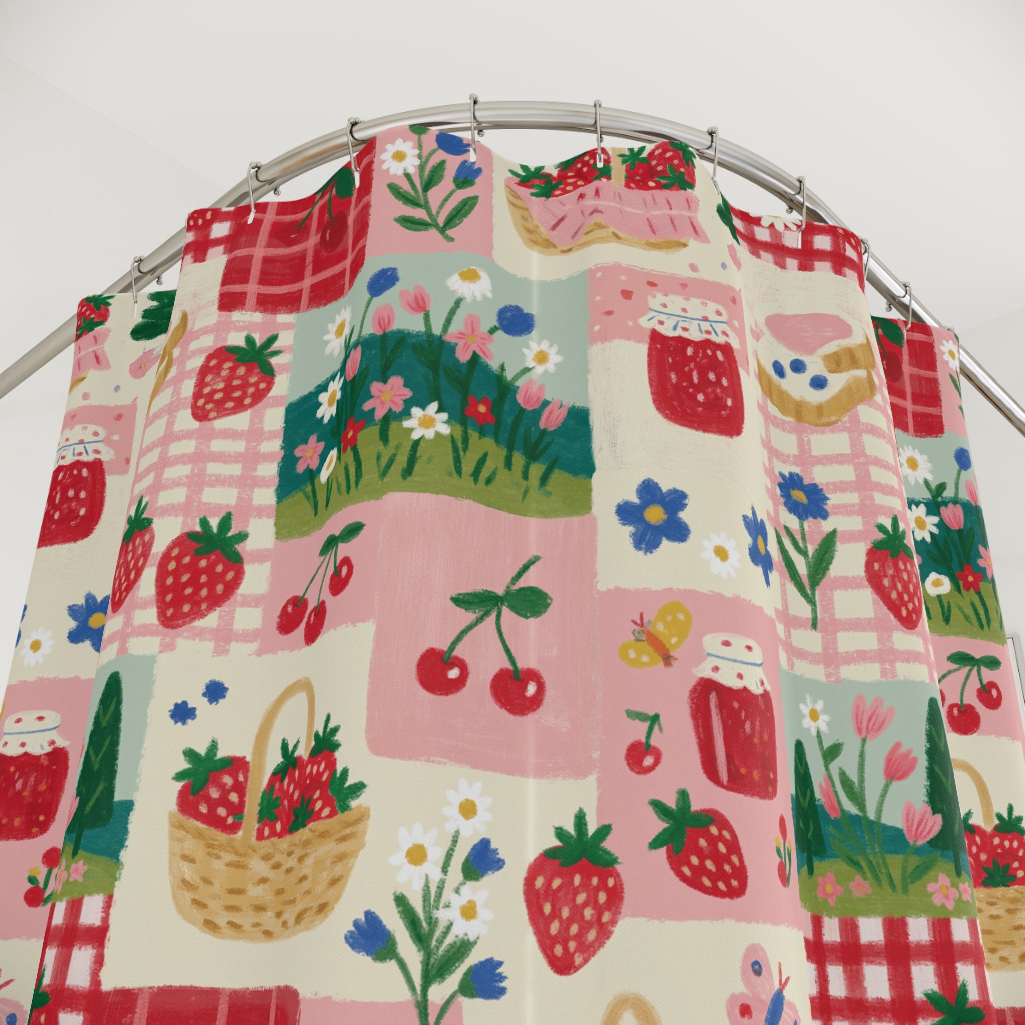 A colorful patterned shower curtain hanging in a bright, modern bathroom. The curtain features a repeating whimsical print of strawberries, baskets, flowers, and red-and-white gingham squares on a light pink background.