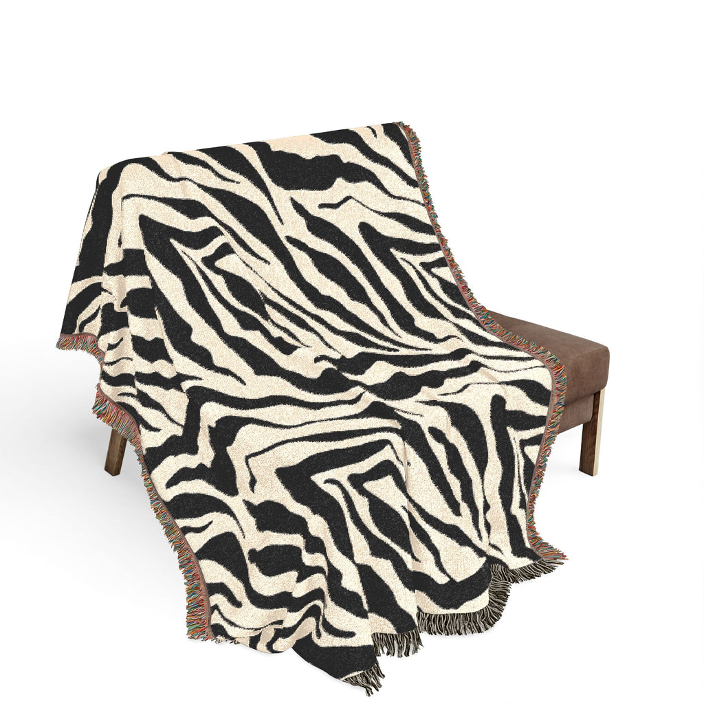 Zebra patterned throw blanket draped over a chair on a white background