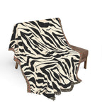 Zebra patterned throw blanket draped over a chair on a white background