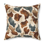 A square throw pillow featuring a watercolor cow print pattern in brown, beige, and slate blue-gray on a white background.