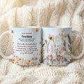 Two ceramic mugs with floral illustrations and a morning greeting printed on them, displayed side by side on a soft cream knit blanket.